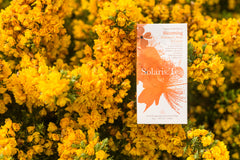 Solaris Blooming Teepackung mit gelben Blumen im Hintergrund